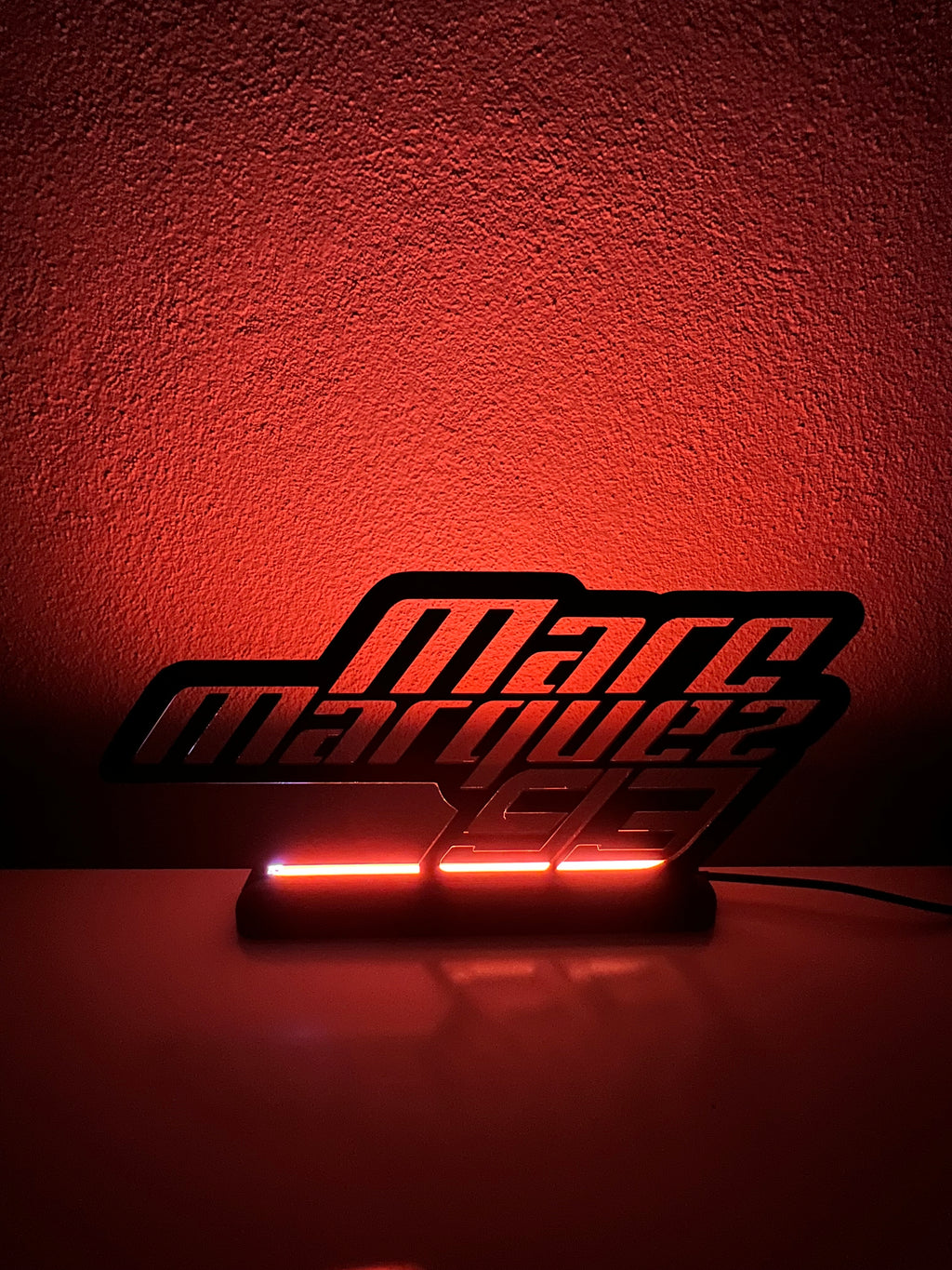 Lampada LED Marc Marquez con luce rossa su base illuminata