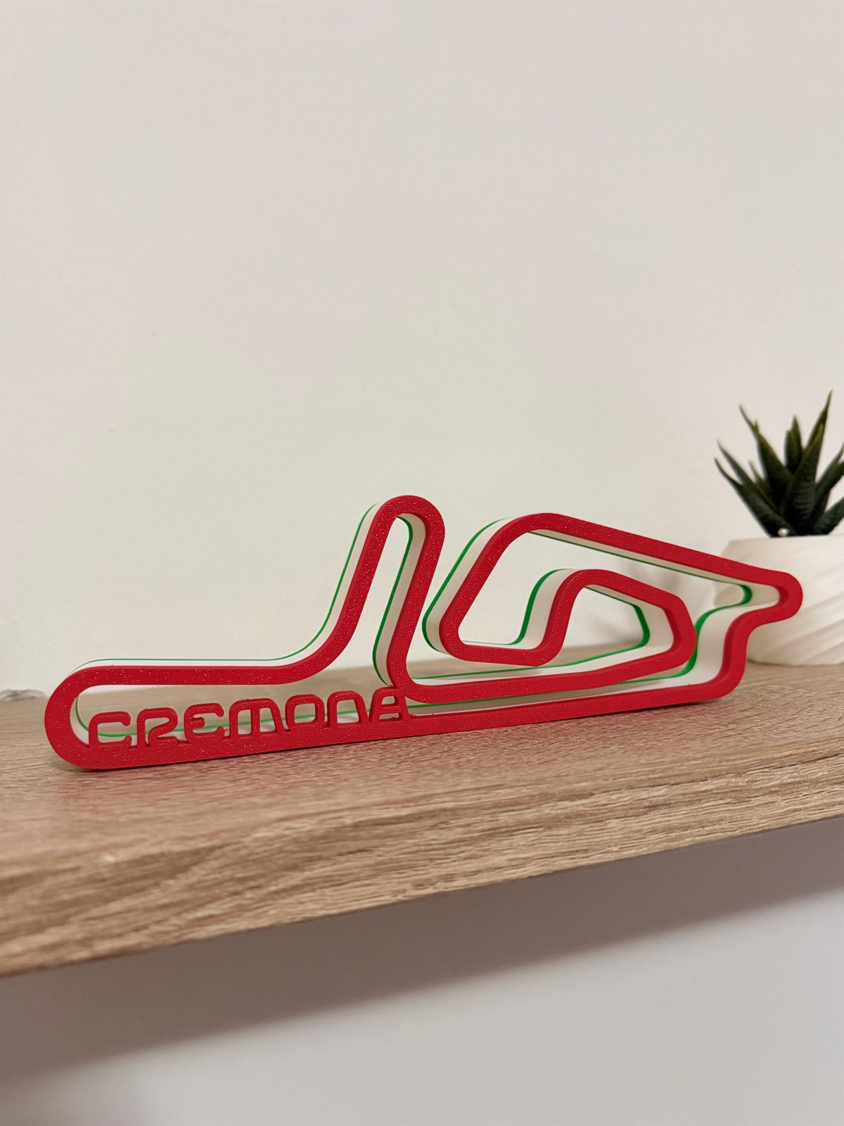 Tracciato 3D Circuito di Cremona su mensola accanto a una pianta